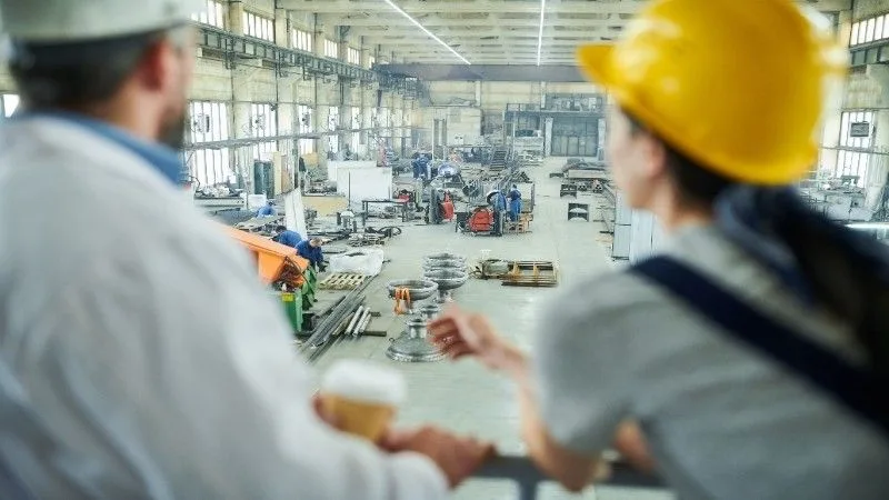 Workers assembling machinery on the production line in a manufacturing facility.