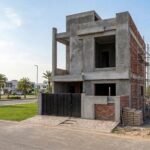 Modern Constructions Company building a two-story grey structure house in a residential community.