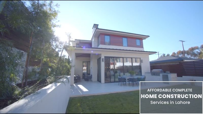 A modern two-story house with a spacious backyard and outdoor seating area, representing affordable complete home construction services in Lahore.