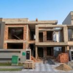 Grey Structure Construction Services in Lahore for a modern double-story house under construction with concrete frame and brick walls.