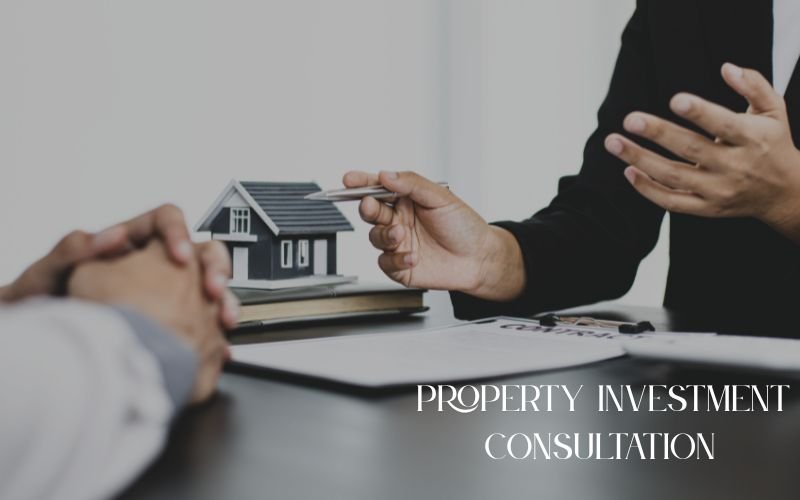 Two people discussing property investment with a house model and documents on the table, highlighting Highland Properties as a leading Real Estate Agency Lahore.
