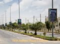 Wide road view with palm trees and modern street lights in DHA Rahbar Phase 1, Lahore.