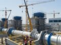 Modern Power and Energy Plant Construction Company site with cranes, engineers, and industrial equipment under development.