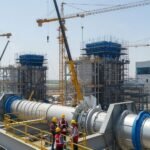 Modern Power and Energy Plant Construction Company site with cranes, engineers, and industrial equipment under development.