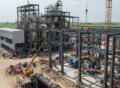 Sugar mill construction site in Pakistan showing steel framework, cranes, and workers assembling a modern industrial plant.