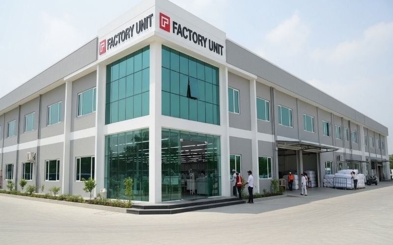 Modern textile and stitching unit building in Pakistan with glass front and industrial architecture representing a leading textile & stitching units construction company in Pakistan.