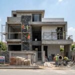 Modern under-construction house showing Grey Structure Construction in DHA Lahore with workers, scaffolding, and ongoing finishing work on a contemporary building exterior.