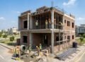 Grey Structure Construction in Lake City Lahore showing a modern house under construction with RCC structure, brick walls, and workers on site during building process