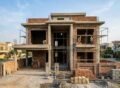 Modern house under construction showing a strong grey structure with workers on site, representing Grey Structure Construction in Park View City Lahore.