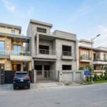 Modern house construction in T&T Aabpara Housing Society with stylish front elevations and parked cars, showcasing House Construction in T&T Aabpara Housing Society.