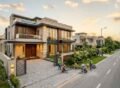 Modern luxury house under construction in a premium residential community, showcasing high-end architecture, landscaped frontage, and professional workmanship, highlighting Turnkey Construction in DHA Lahore.